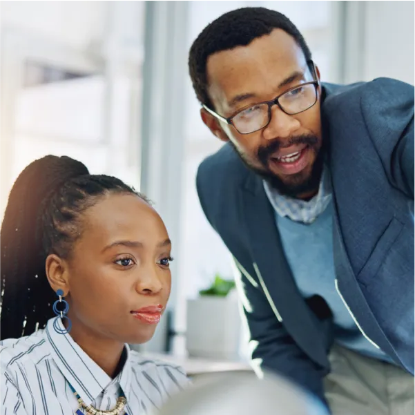 A man and a woman looking at a computer screen.