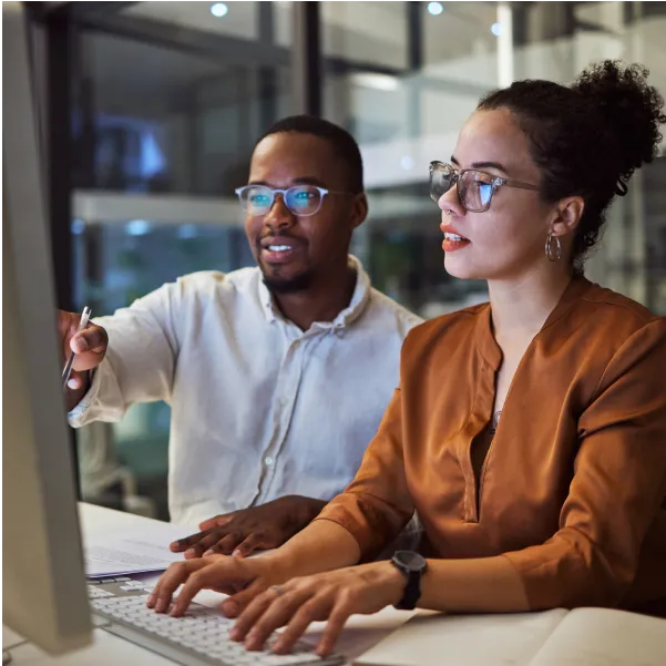 A man and a woman sitting in front of a computer.