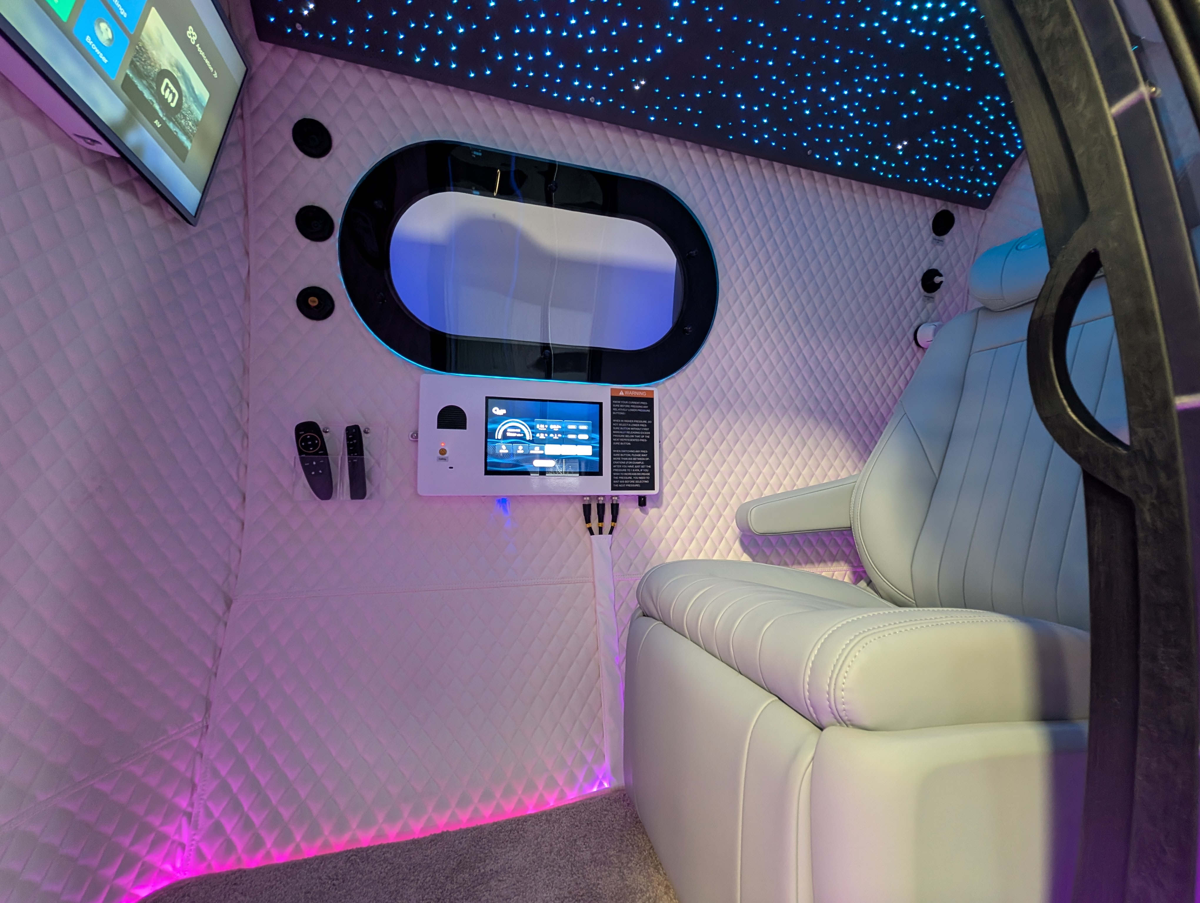 Inside a Mind Spa hyperbaric chamber: padded recliner seat beside a large window
