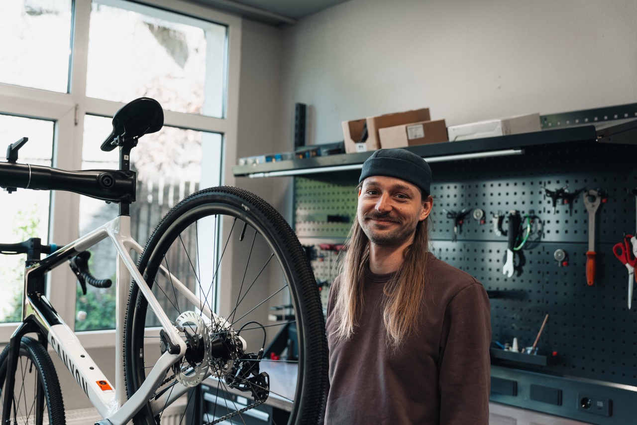 Mechaniker der alf cycling Canyon ASP Werkstatt neben einem Bike