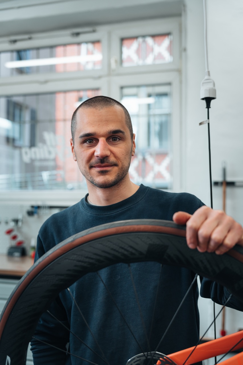 Mechaniker mit Laufrad in der alf cycling Allbrands Werkstatt West in Stuttgart