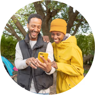 A man and woman engaged in conversation while examining a phone together