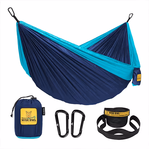 A two-tone blue and teal hammock is displayed alongside its compact storage bag, two black carabiners, and a set of tree-friendly straps,