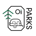 A logo on a white background featuring a stylized octagonal border. Inside, there's a line drawing of a small camper trailer, a pine tree, and the text "Oi". The word "PARKS" is written vertically along the right side of the octagonal border.