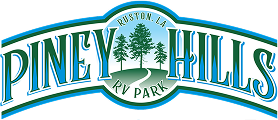 The logo for "Piney Hills RV Park," featuring a green and blue arched design with "PINEY HILLS" in bold letters. The center includes stylized pine trees and a winding road, with "RUSTON, LA" and "RV PARK" curving above and below, respectively.