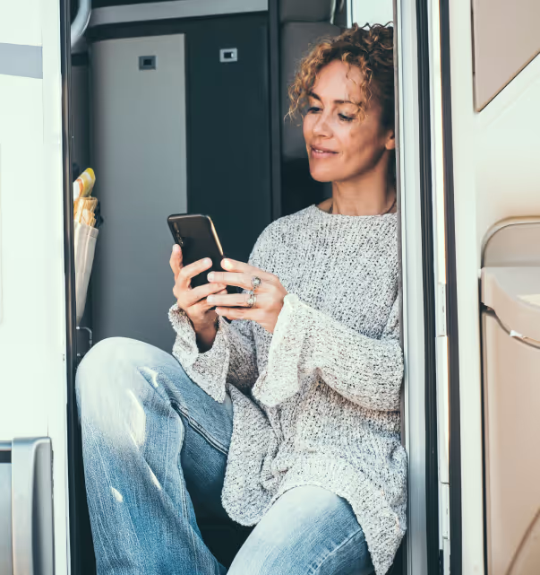 Person looking at their phone receiving a notification about their campground