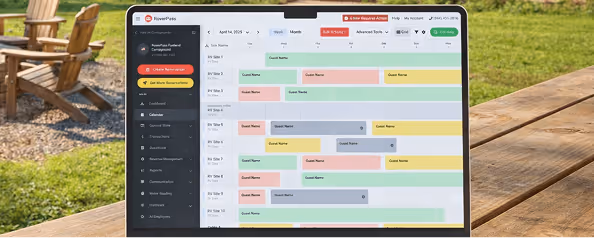 A laptop screen displaying a professional campground management calendar with color-coded guest bookings and site availability.