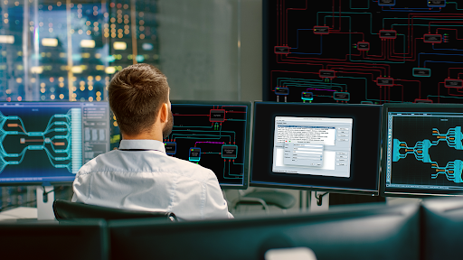 Control room operator analyzing real-time system data and geospatial visualization on large displays