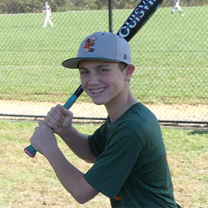 A waist up shot of Elkridge Hurricanes player Caleb Neal in his batting stance looking at the camera.