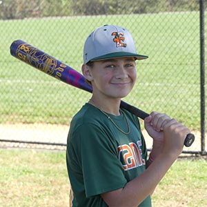 A half body shot of Elkridge Hurricanes player Rocky Lee in his batting stance looking at the camera.
