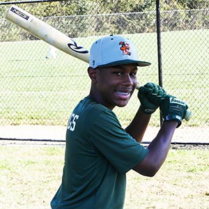 A shot from the waist up of of Elkridge Hurricanes player Nigel Jennings in his batting stance looking at the camera.