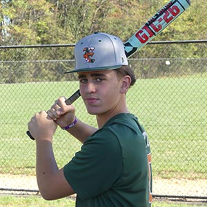 A shot from the waist up of Elkridge Hurricanes player Joe Upton in his batting stance looking at the camera.