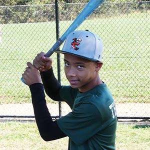 A waist up shot of Elkridge Hurricanes player Nick Thompson in his batting stance looking at the camera.