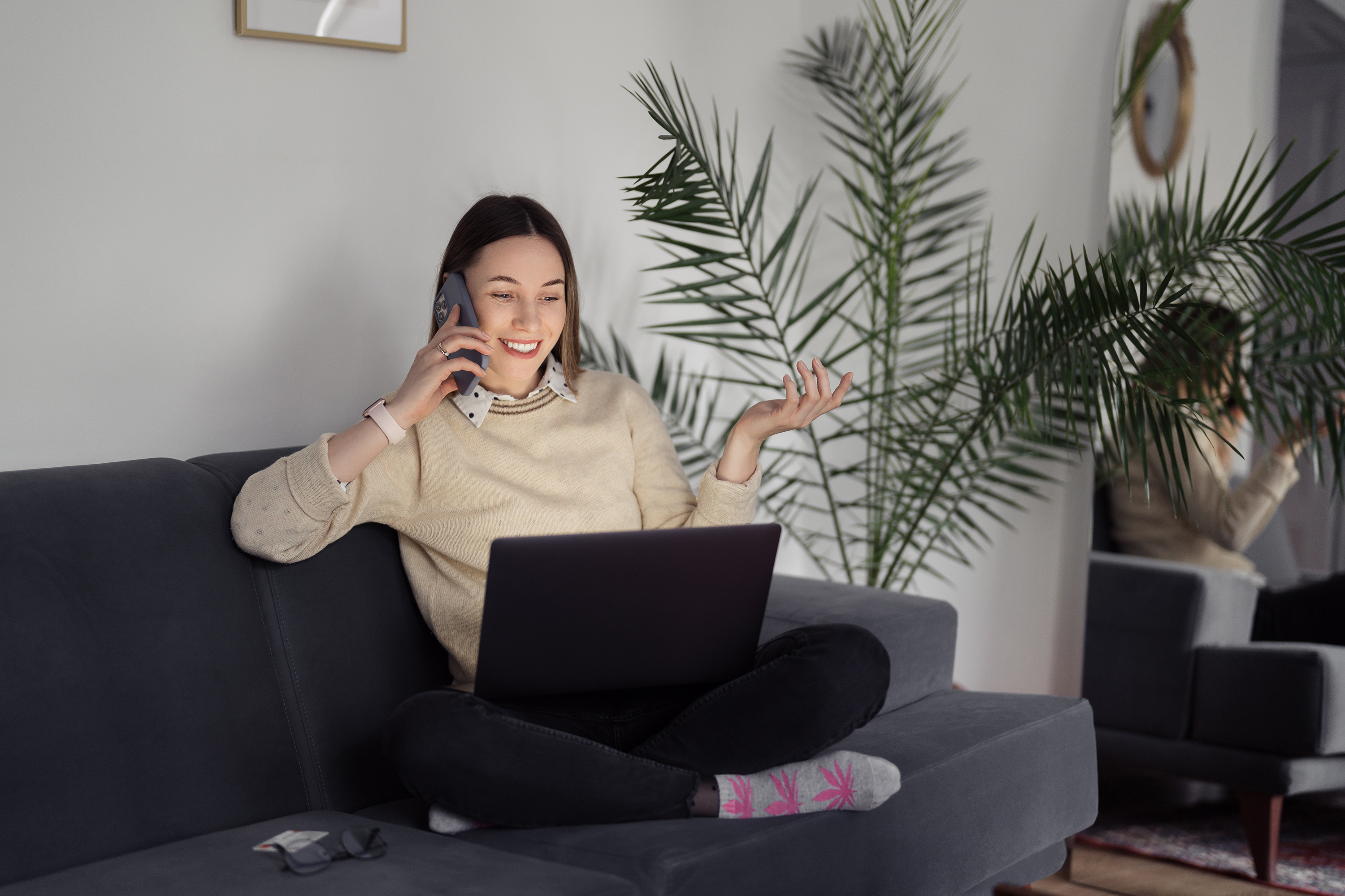 Remote worker on a phone call while using a laptop from home.
