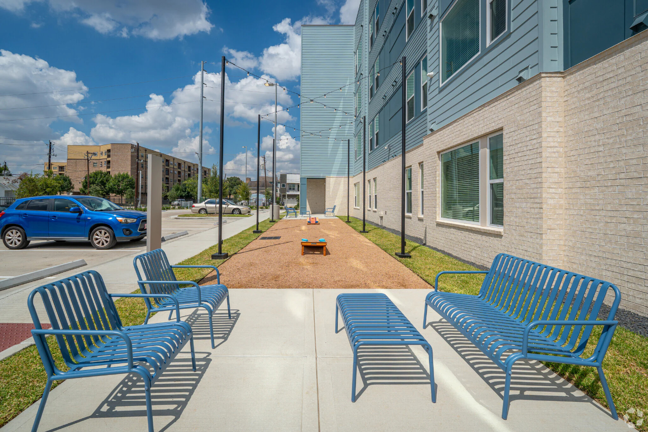 seating area by exterior corn hole game