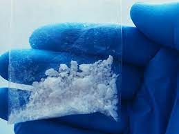 An illustration representing carfentanil, a synthetic opioid, with a blurred background of related substances.