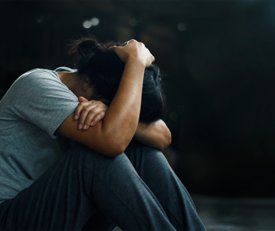 A person reflecting on their mental health while holding a drink, representing the consequences of stopping alcohol consumption.
