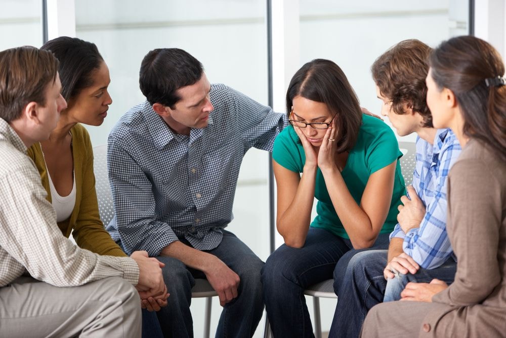 A diverse group of individuals engaged in a therapy session, focusing on alternatives to Adderall for ADHD.
