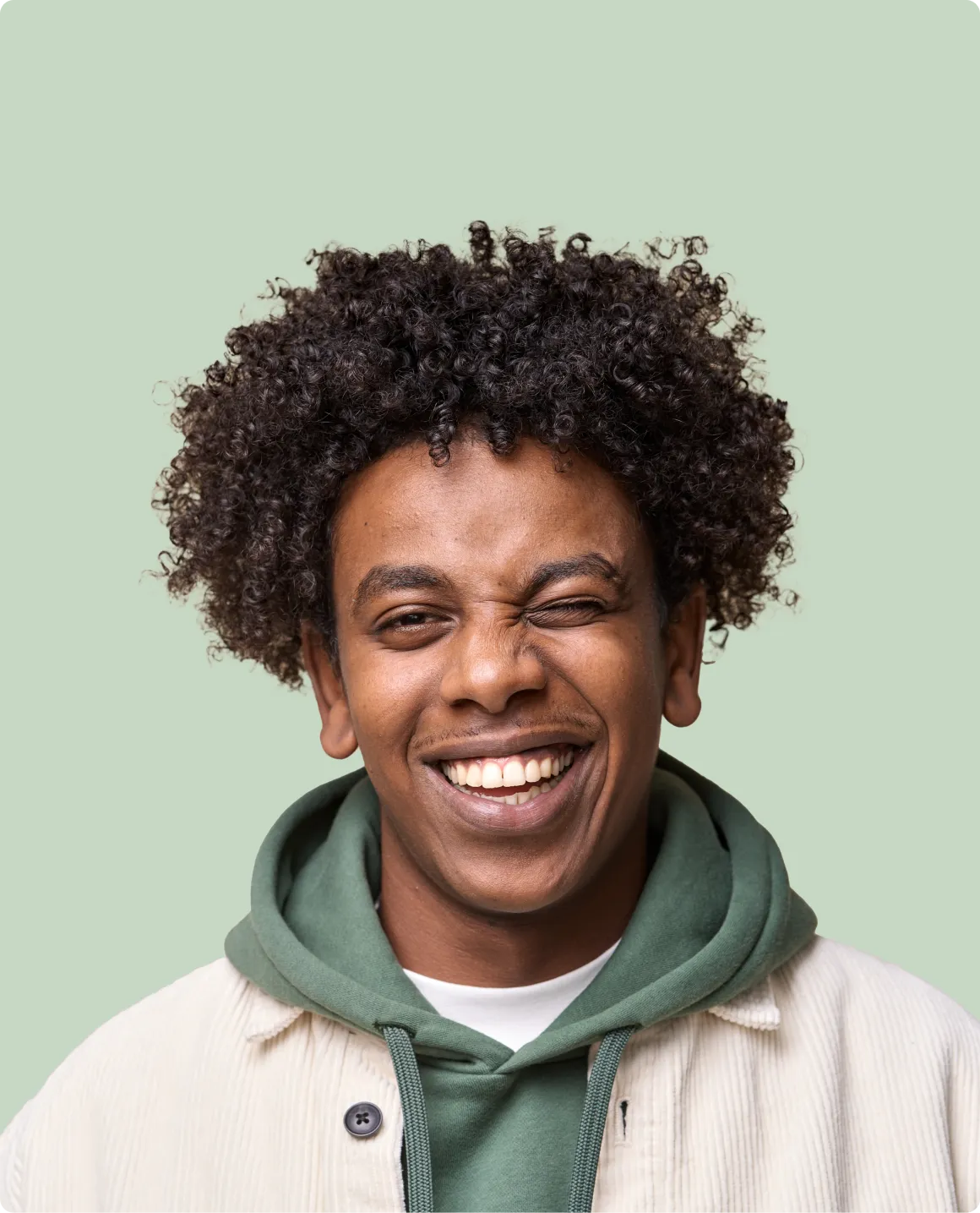 A man with curly hair smiling at the camera.