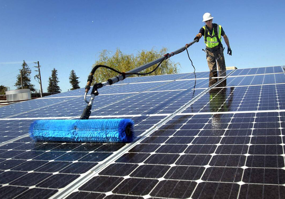 Man cleaning solar panels as part of maintenance action