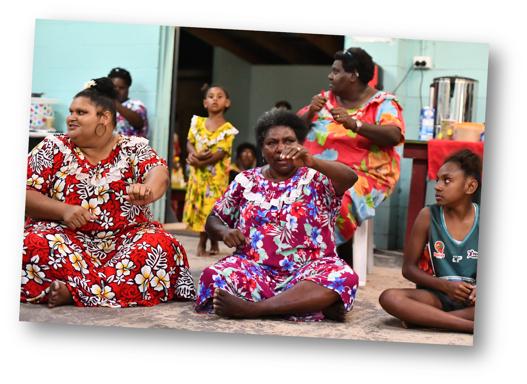 Women sitting down in colourful dresses from the Torres Strait