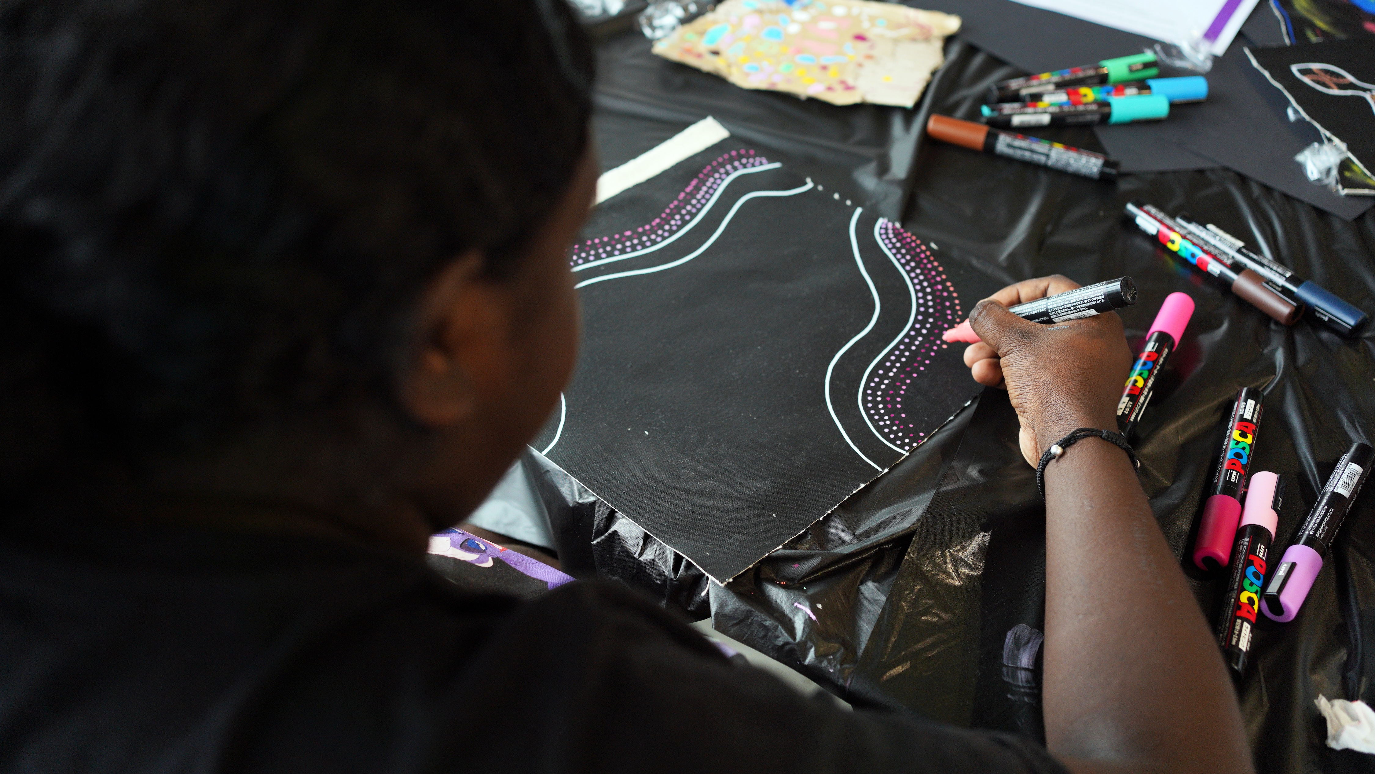 Photo of women drawing on black canvas