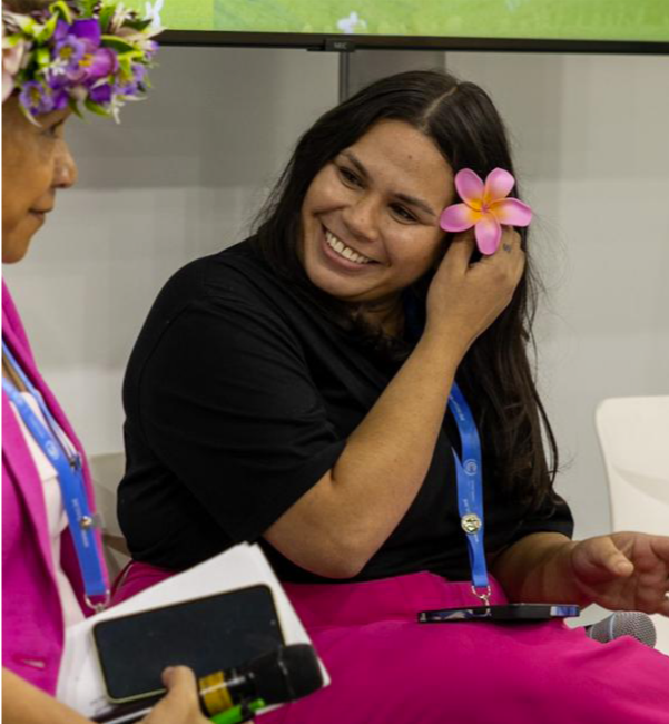 Terri Reid sitting on stage, smiling with a flower in her hair.