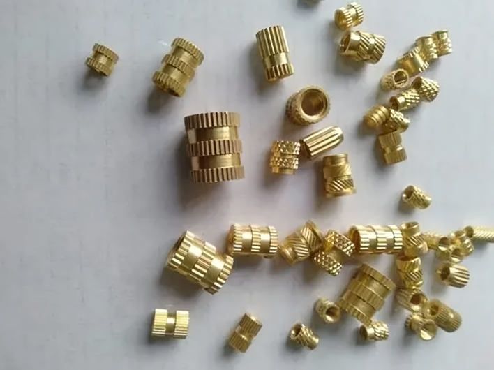 Custom brass nuts and inserts showcasing corrosion