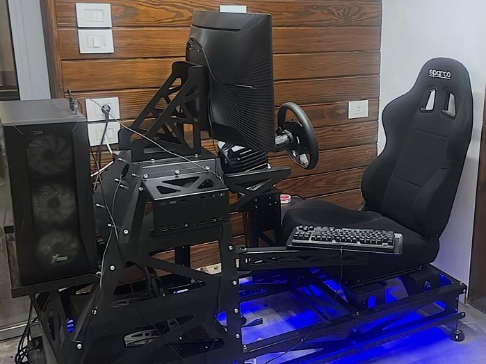 A gaming chair with a keyboard and a computerDescription automatically generated