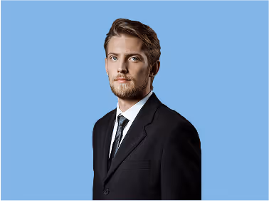 Young man in a suit on a light blue background.