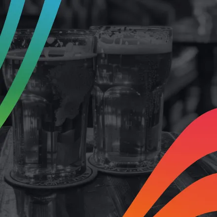 Two pint glasses of beer on a pub table