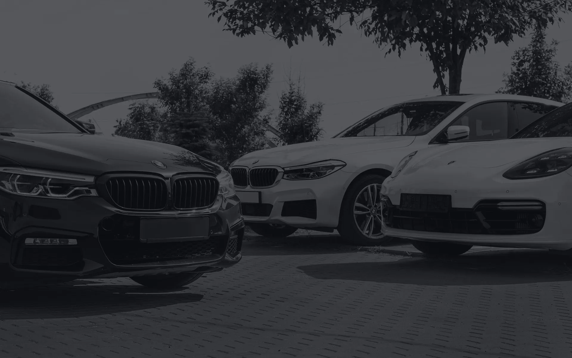 Two BMWs and a Porsche parked next to each other