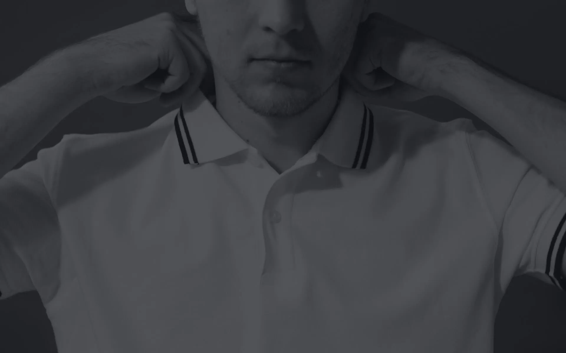 Man adjusting collar of polo shirt