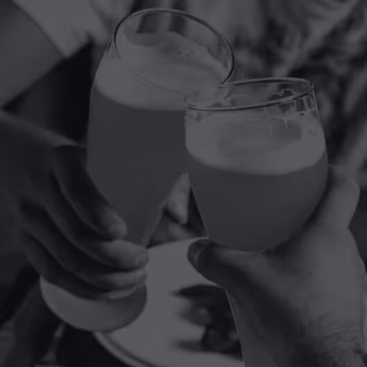Two men toasting with beer over a pub dinner