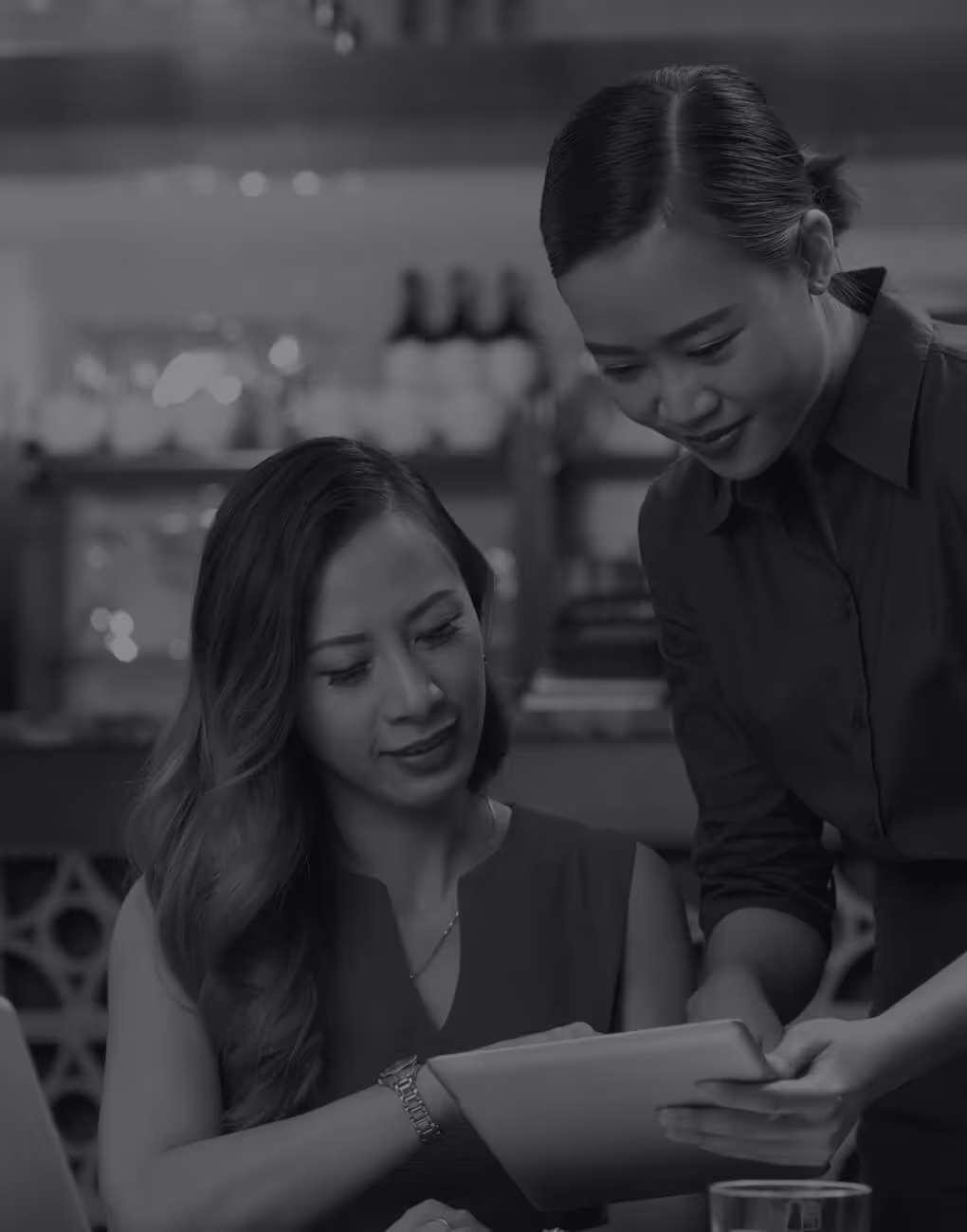 A waitress taking payment from a customer