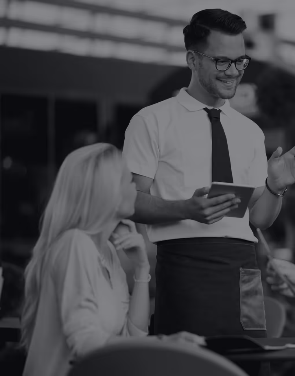 A waiter taking an order from customers at a restaurant