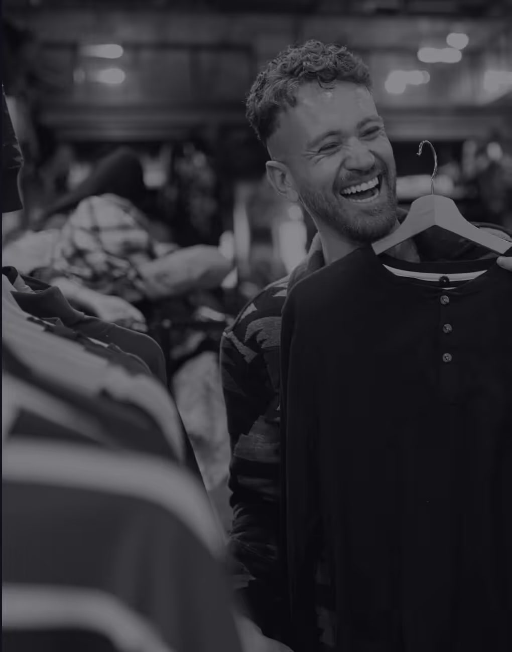 Young man smiling while trying on clothes in a store