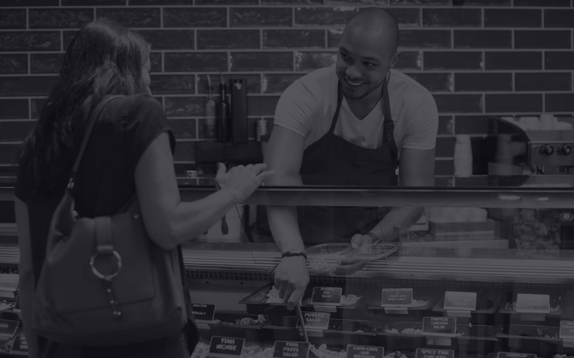 Woman being served at a deli counter