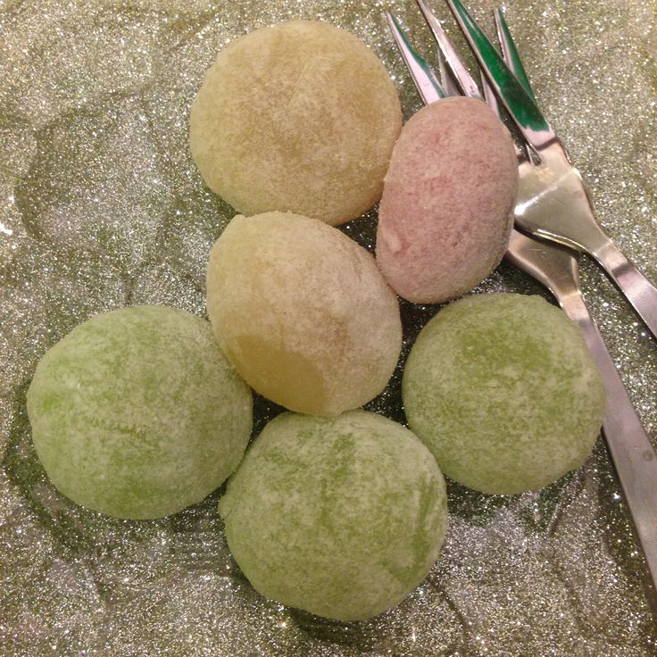 This may contain: four different colored balls on a table next to silverware and utensils with forks