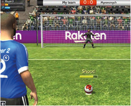 Soccer video game scene showing a penalty kick about to be taken, with a goalkeeper ready in front of the net. The background features a large Rakuten advertising banner as visible in-game advertising.