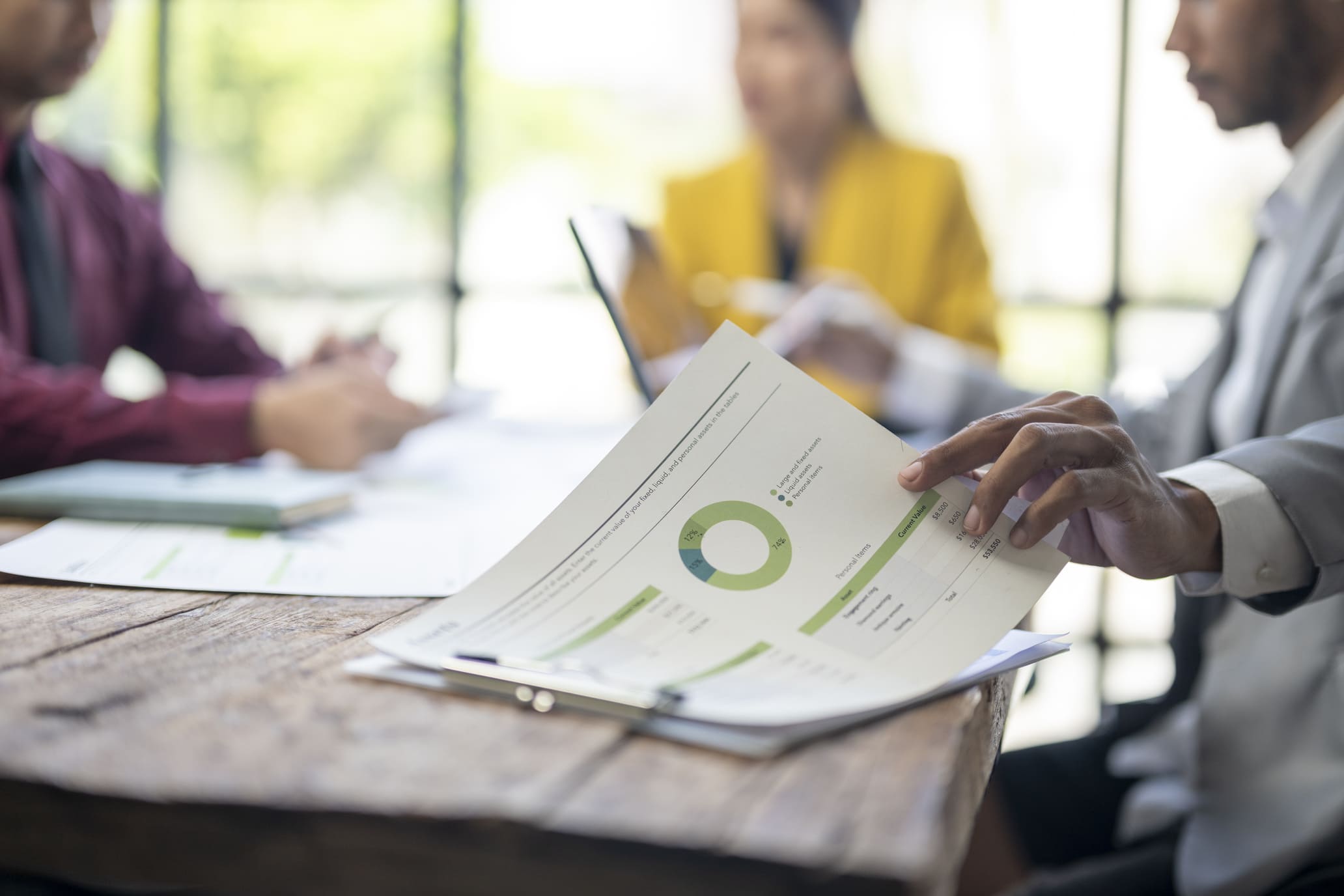 Close-up of financial report with pie chart during business meeting symbolizing ONCA financial statement requirements for Ontario not-for-profits.