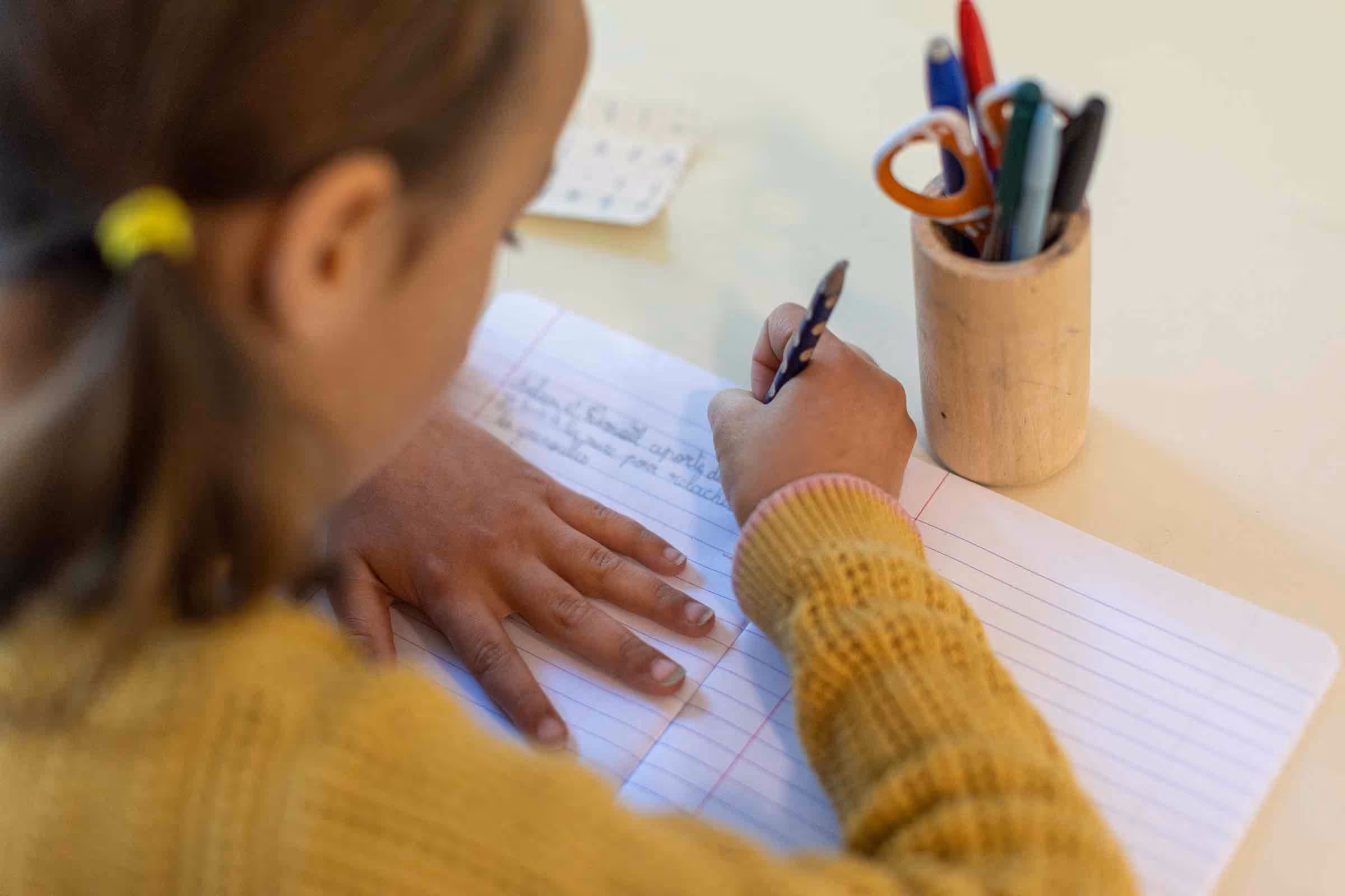 Une élève du Lieu Utile, école alternative à Nantes écrit dans son cahier.
