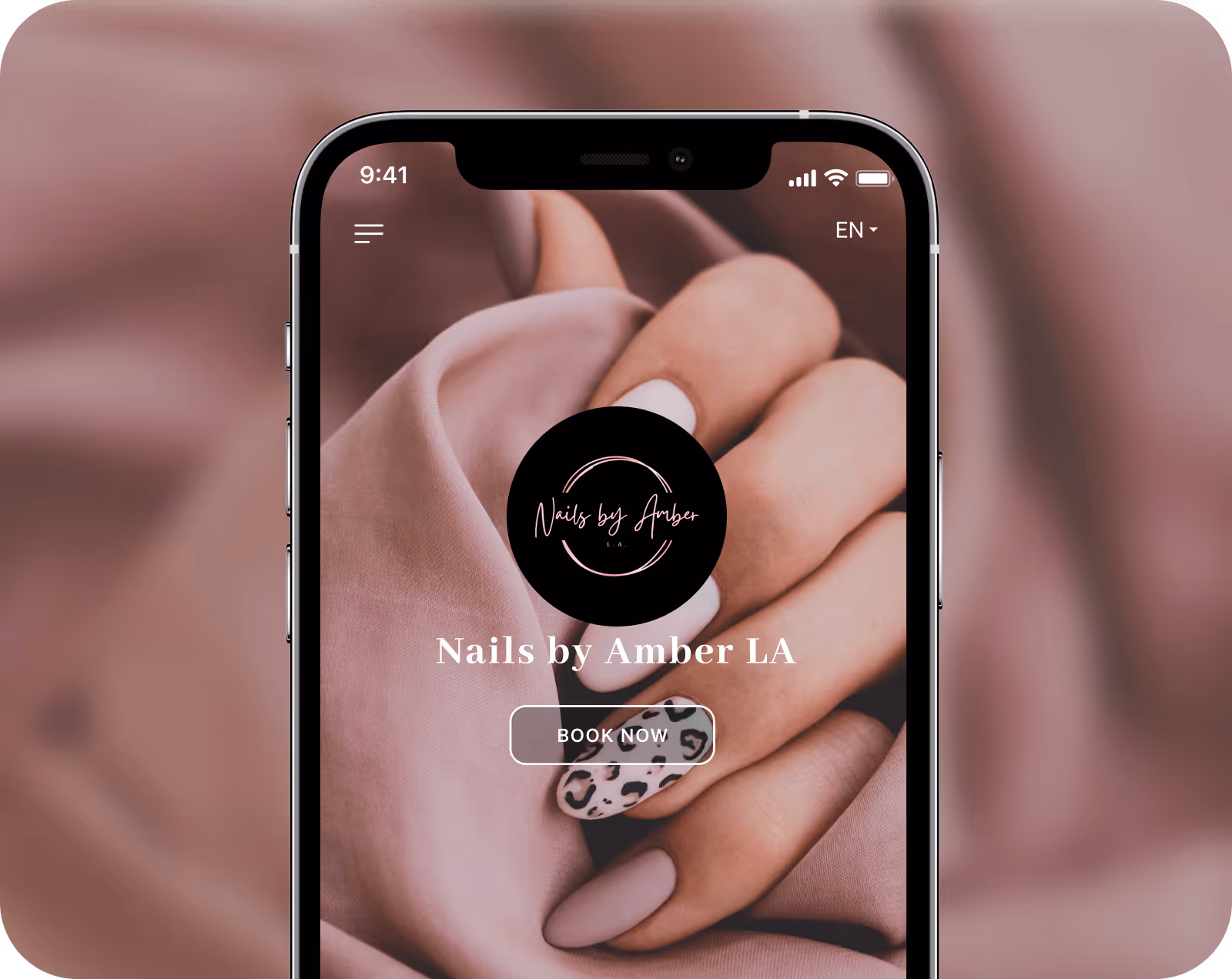 Smartphone screen showing Nails by Amber LA app with manicured hand featuring matte and leopard print nails and a 'Book Now' button.