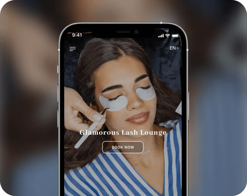 Phone screen showing a woman receiving eyelash treatment with under-eye pads, with text 'Glamorous Lash Lounge' and a 'Book Now' button.
