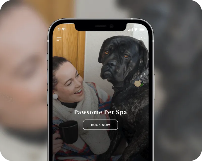Smartphone screen displaying 'Pawsome Pet Spa' booking page with a smiling woman holding a black mug next to a large black dog.