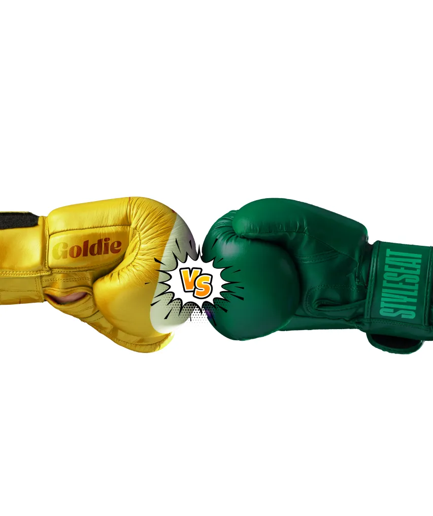 Yellow boxing glove labeled 'Goldie' facing a green boxing glove labeled 'StyleSeat' with a comic-style 'VS' between them.