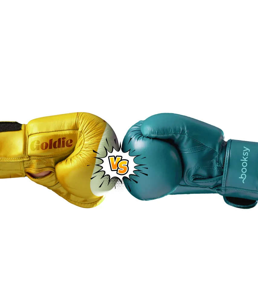 Yellow boxing glove labeled 'Goldie' facing teal boxing glove labeled 'Booksy' with a comic style 'VS' between them.