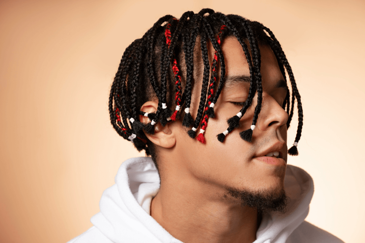 Man with box braids for men featuring red extensions and beads