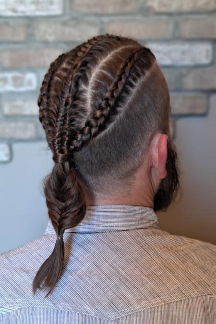 Man with warrior braid for men showing cornrows on top flowing into a single fishtail braid with shaved sides
