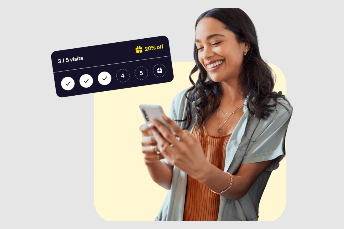 A happy salon client smiling while checking her loyalty program progress on her smartphone